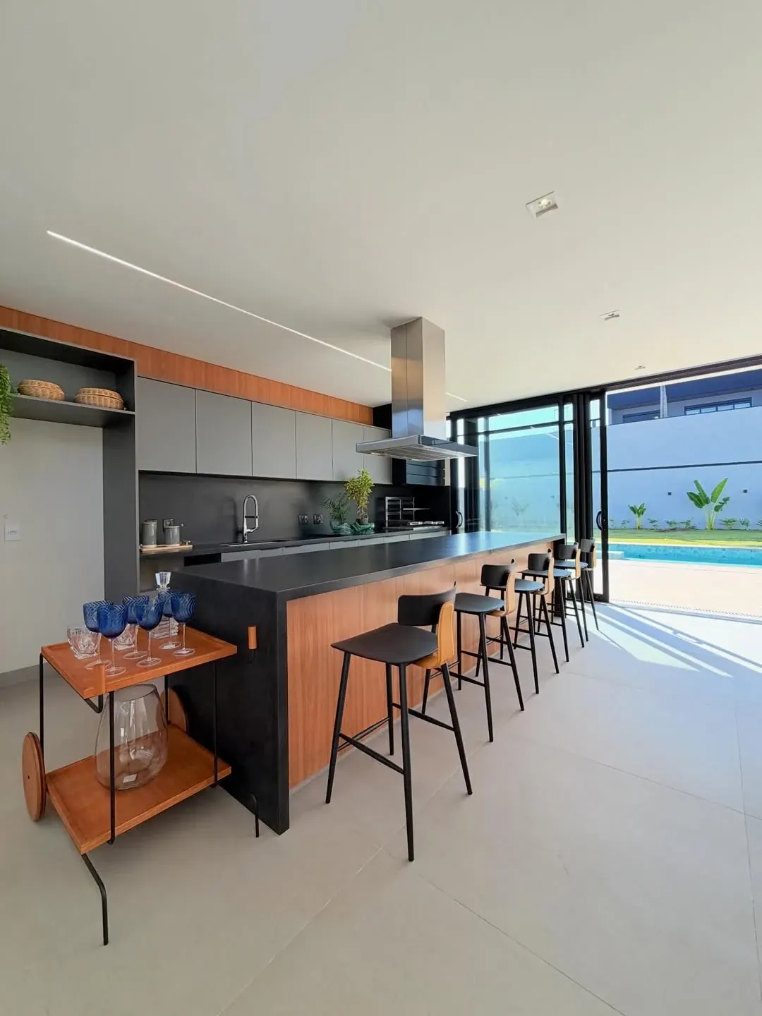 Sala de jantar integrada à cozinha e à piscina em residência contemporânea